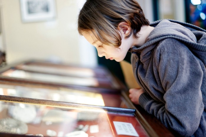 Girl looking at a glass display in museum